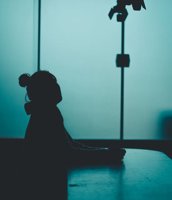 Woman in a calm, balanced pose against a dark background with amber light.